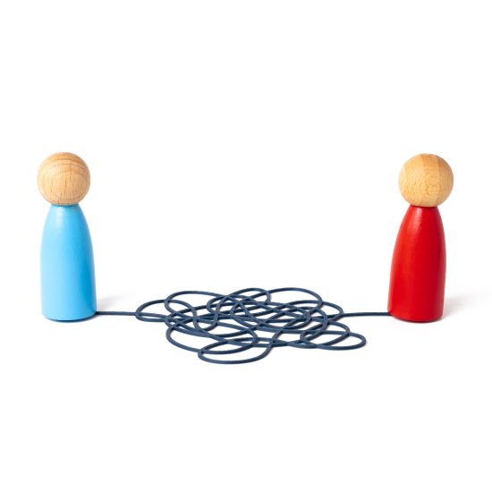 Two wooden figures connected by a length of tangled string